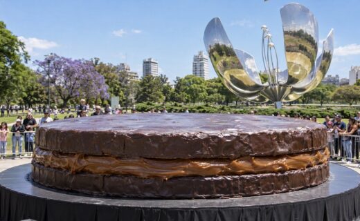 Alfajor gigante cubierto de chocolate frente a la Floralis Genérica, rodeado de público en la Plaza de las Naciones Unidas de Recoleta.