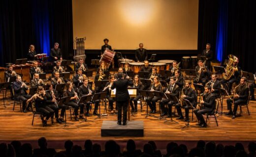 Banda Sinfónica porteña durante un concierto de música de películas en un escenario cultural.