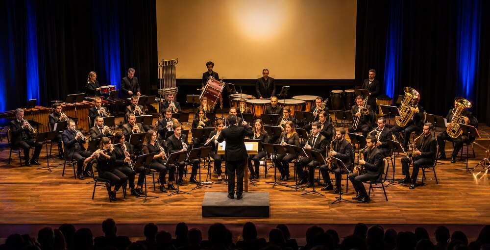 Banda Sinfónica porteña durante un concierto de música de películas en un escenario cultural.