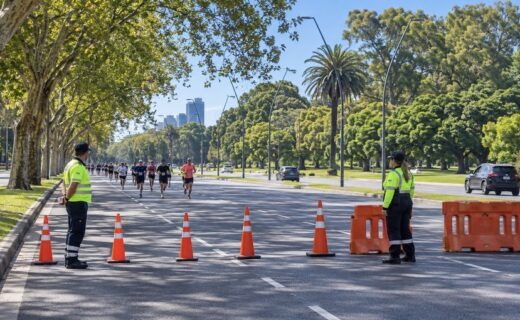 Corte de tránsito sobre la avenida Figueroa Alcorta con agentes, conos de seguridad y corredores durante un evento deportivo en Buenos Aires.