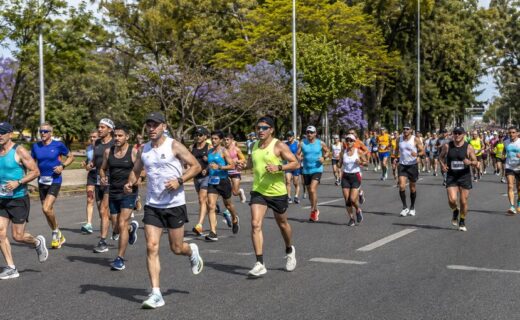 Corredores de la Maratón de Buenos Aires 42K avanzan por una avenida arbolada de Palermo.