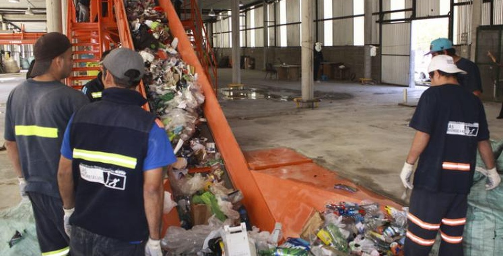 Recuperadores urbanos clasifican materiales reciclables en una cinta del Centro Verde de Núñez, en Buenos Aires.
