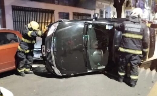 Bomberos trabajan junto a un auto volcado de costado tras el choque en Cabildo y Manuela Pedraza, donde una persona resultó herida.