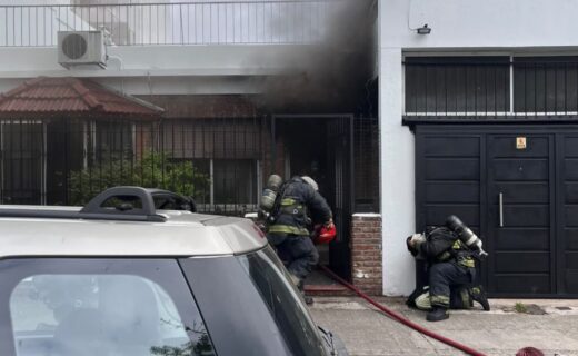 Bomberos trabajan frente a la vivienda incendiada en Manuel Rodríguez al 2500, en La Paternal.