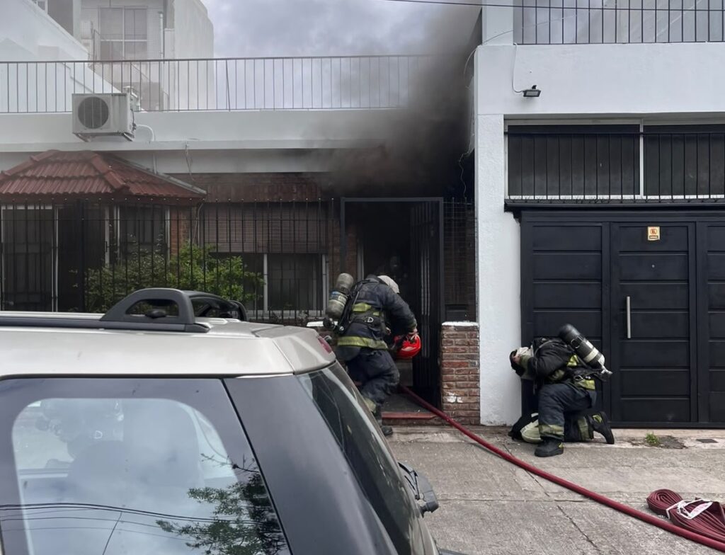 Bomberos trabajan frente a la vivienda incendiada en Manuel Rodríguez al 2500, en La Paternal.