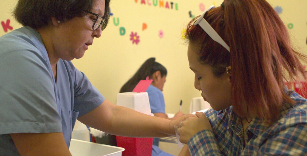 Una profesional de salud aplica una vacuna durante la campaña contra el dengue en CABA.